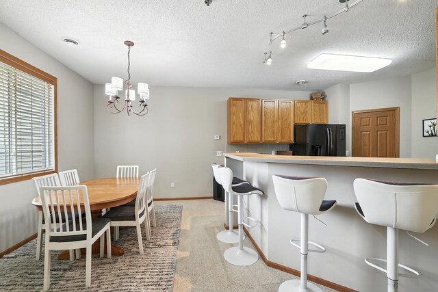 451 Frederick Cir Unit 1405, Hastings, MN 55033 - kitchen with black refrigerator with ice dispenser, a kitchen bar, a chandelier, light carpet, and a textured ceiling