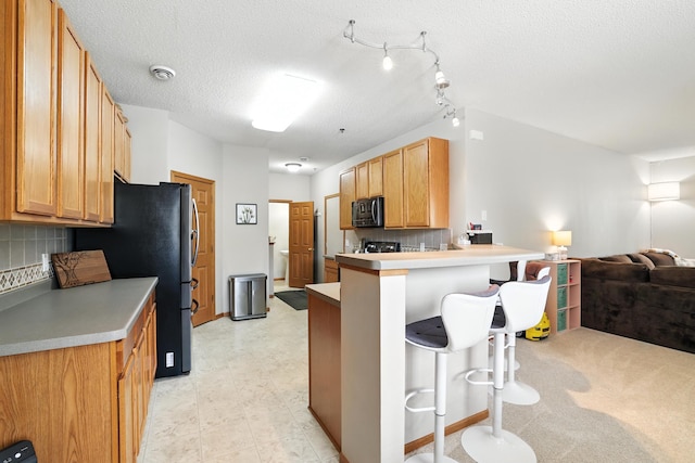 451 Frederick Cir Unit 1405, Hastings, MN 55033 - kitchen with black microwave, open floor plan, a breakfast bar, a peninsula, and tasteful backsplash