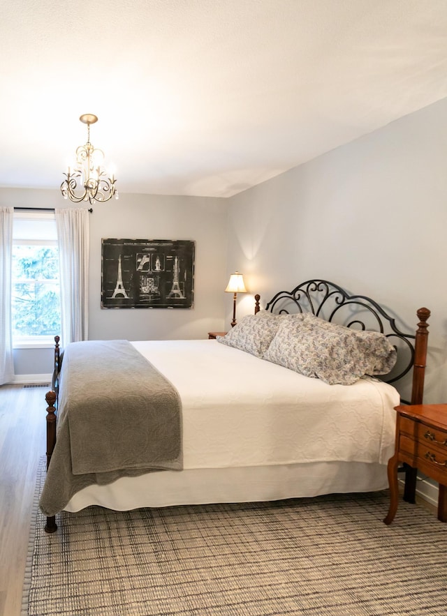6045 Galpin Lake Rd, Shorewood, MN 55331 - bedroom with a chandelier and wood finished floors