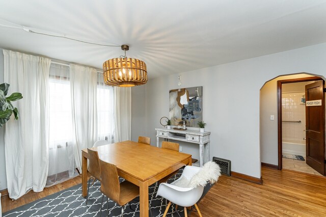 1130 4th Ave SE, Rochester, MN 55904 - dining room with arched walkways, a chandelier, and light wood-style flooring