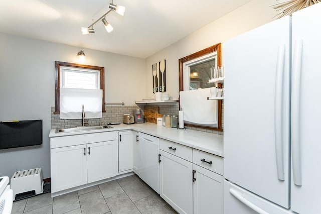 1130 4th Ave SE, Rochester, MN 55904 - kitchen featuring white appliances, tasteful backsplash, light tile patterned floors, light countertops, and white cabinetry