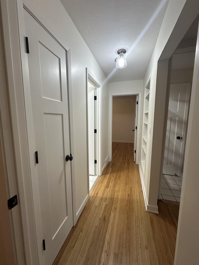2325 Crosstown Blvd NE, Ham Lake, MN 55304 - hall featuring built in shelves, light wood-style floors, and a textured ceiling