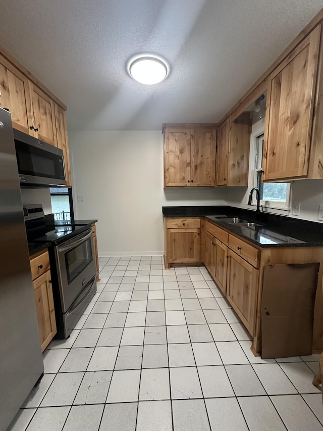 2325 Crosstown Blvd NE, Ham Lake, MN 55304 - kitchen with appliances with stainless steel finishes, dark countertops, a textured ceiling, and light tile patterned floors