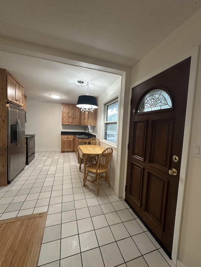 2325 Crosstown Blvd NE, Ham Lake, MN 55304 - foyer entrance with light tile patterned floors and a chandelier