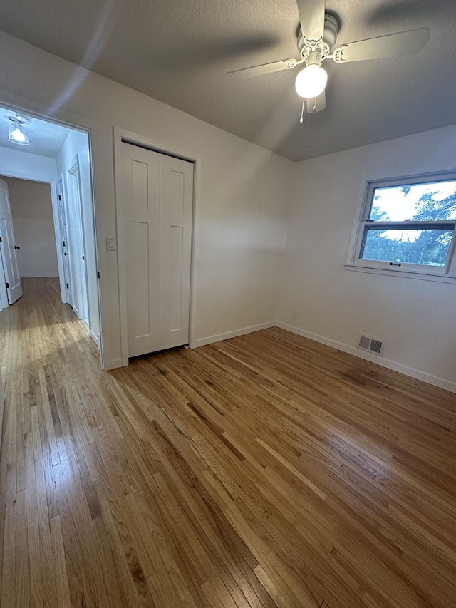 2325 Crosstown Blvd NE, Ham Lake, MN 55304 - unfurnished bedroom with wood finished floors, a closet, and a ceiling fan