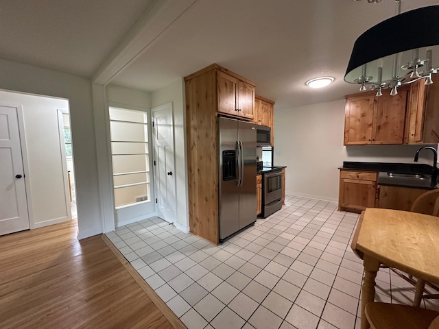 2325 Crosstown Blvd NE, Ham Lake, MN 55304 - kitchen with appliances with stainless steel finishes, dark countertops, light wood-style flooring, and brown cabinets