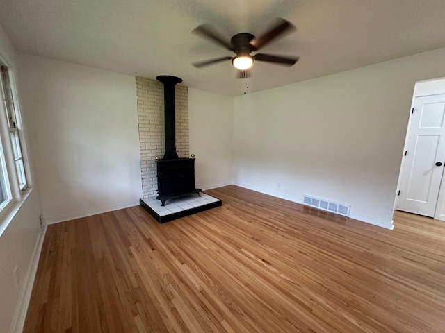 2325 Crosstown Blvd NE, Ham Lake, MN 55304 - unfurnished living room with a ceiling fan, light wood-style floors, and a wood stove