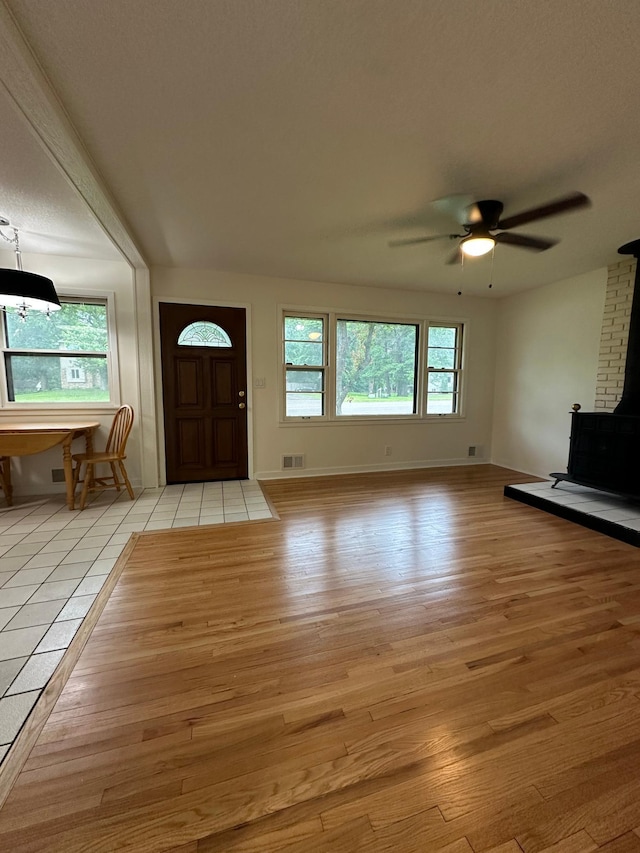 2325 Crosstown Blvd NE, Ham Lake, MN 55304 - foyer entrance featuring a wood stove, light wood-type flooring, and a ceiling fan