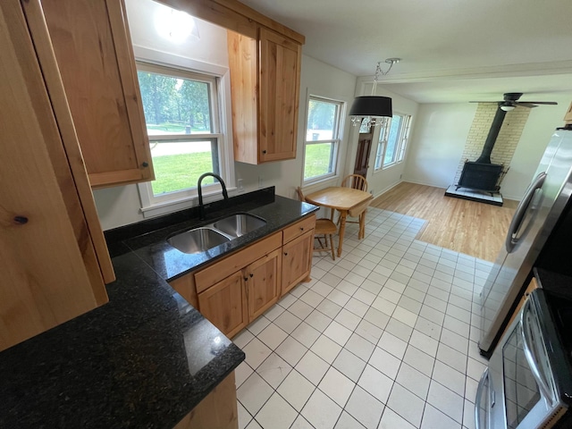 2325 Crosstown Blvd NE, Ham Lake, MN 55304 - kitchen featuring a wood stove, light tile patterned floors, open floor plan, decorative light fixtures, and dark stone counters