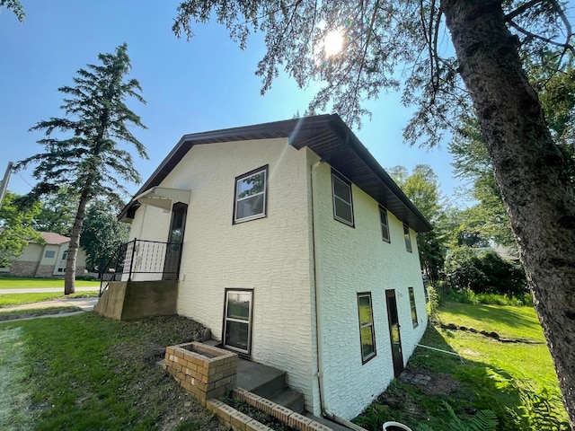 2325 Crosstown Blvd NE, Ham Lake, MN 55304 - view of property exterior featuring stucco siding and a lawn