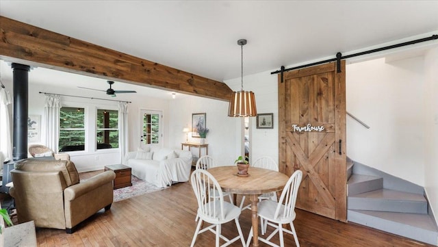 21038 Lace Ave, Hutchinson, MN 55350 - dining space featuring a barn door, wood finished floors, stairway, and ceiling fan