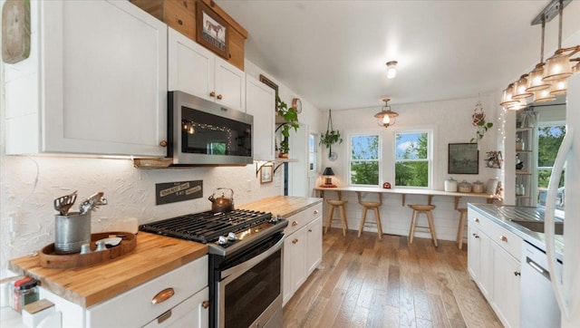 21038 Lace Ave, Hutchinson, MN 55350 - kitchen with stainless steel appliances, butcher block counters, light wood finished floors, and white cabinets