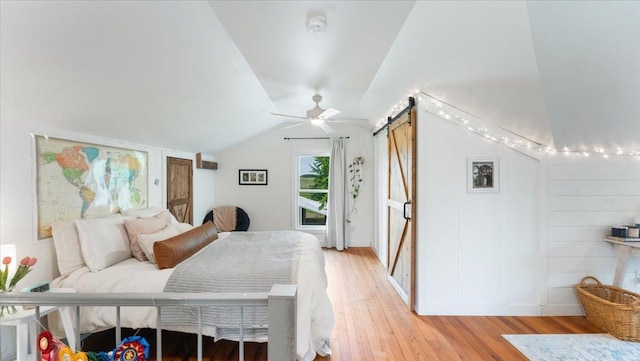 21038 Lace Ave, Hutchinson, MN 55350 - bedroom with a barn door, light wood-style floors, and vaulted ceiling