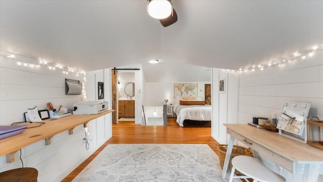 21038 Lace Ave, Hutchinson, MN 55350 - bedroom with wood finished floors, a barn door, and lofted ceiling