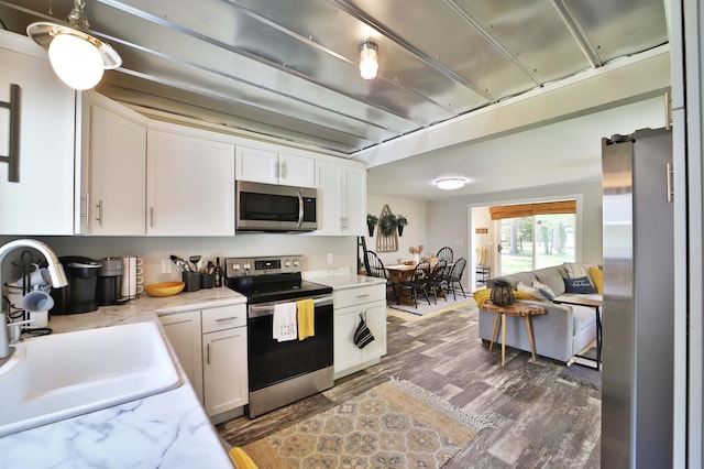 10032 Long Lake Rd, Brainerd, MN 56401 - kitchen with stainless steel appliances, white cabinetry, wood finished floors, and light stone counters