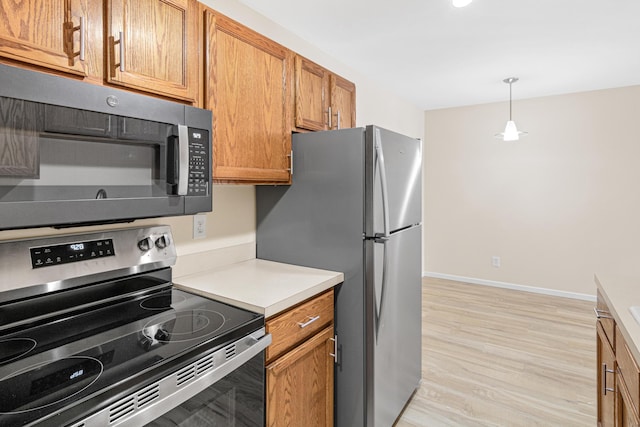 2801 Flag Ave N Unit 203, New Hope, MN 55427 - kitchen featuring stainless steel appliances, light wood-style floors, light countertops, brown cabinets, and decorative light fixtures