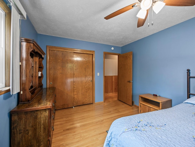3945 8th Ave NW, Anoka, MN 55303 - bedroom with wood finished floors, a textured ceiling, a ceiling fan, and a closet