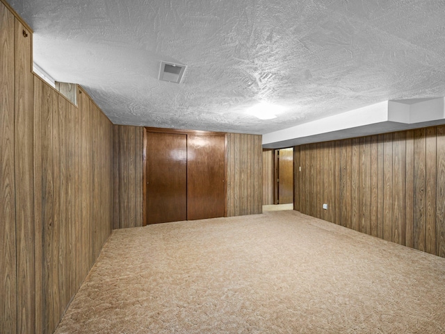 3945 8th Ave NW, Anoka, MN 55303 - finished below grade area featuring wood walls, a textured ceiling, and carpet floors