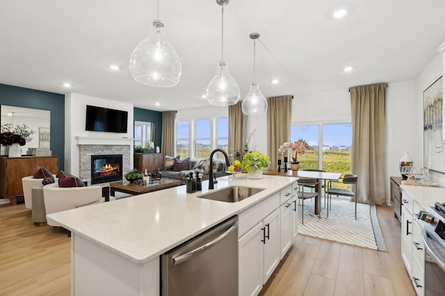 7579 Swan St, Lino Lakes, MN 55038 - kitchen featuring appliances with stainless steel finishes, a center island with sink, light wood-type flooring, light countertops, and recessed lighting
