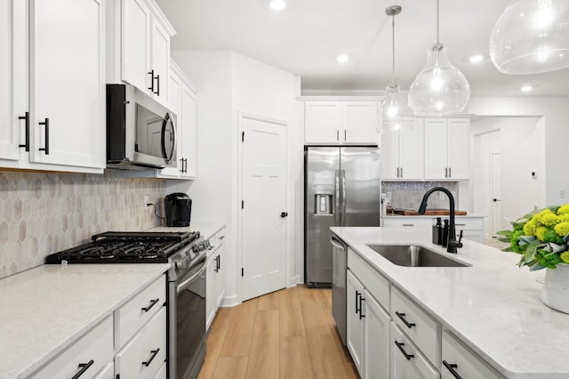 7579 Swan St, Lino Lakes, MN 55038 - kitchen with appliances with stainless steel finishes, white cabinetry, light wood finished floors, recessed lighting, and tasteful backsplash