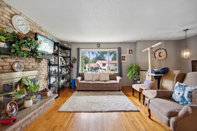 1613 Lyn Curve Ave N, Minneapolis, MN 55411 - living area featuring a textured ceiling, wood finished floors, a fireplace, and a chandelier