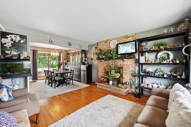 1613 Lyn Curve Ave N, Minneapolis, MN 55411 - living area with a chandelier, wood finished floors, and a brick fireplace