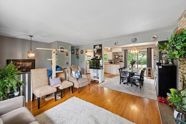 1613 Lyn Curve Ave N, Minneapolis, MN 55411 - living room featuring a chandelier and light wood-style floors