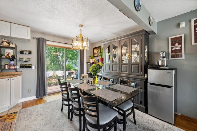 1613 Lyn Curve Ave N, Minneapolis, MN 55411 - dining space featuring a chandelier, a textured ceiling, and light wood finished floors