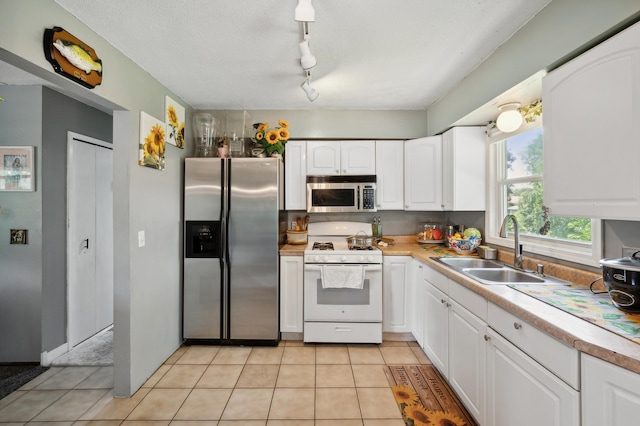 1613 Lyn Curve Ave N, Minneapolis, MN 55411 - kitchen featuring appliances with stainless steel finishes, white cabinetry, light countertops, and light tile patterned floors