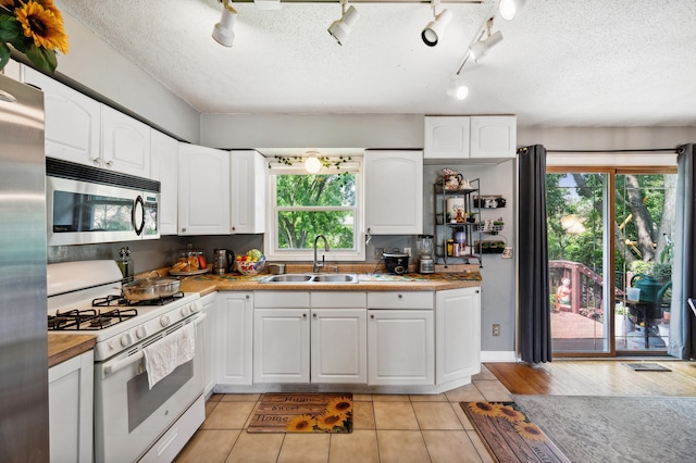 1613 Lyn Curve Ave N, Minneapolis, MN 55411 - kitchen featuring stainless steel appliances, plenty of natural light, white cabinetry, track lighting, and a textured ceiling