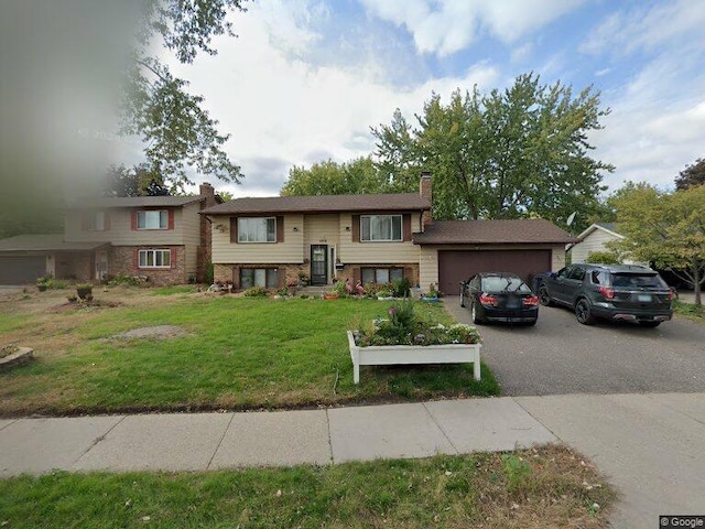 1613 Lyn Curve Ave N, Minneapolis, MN 55411 - split foyer home featuring a chimney, a front yard, an attached garage, and asphalt driveway
