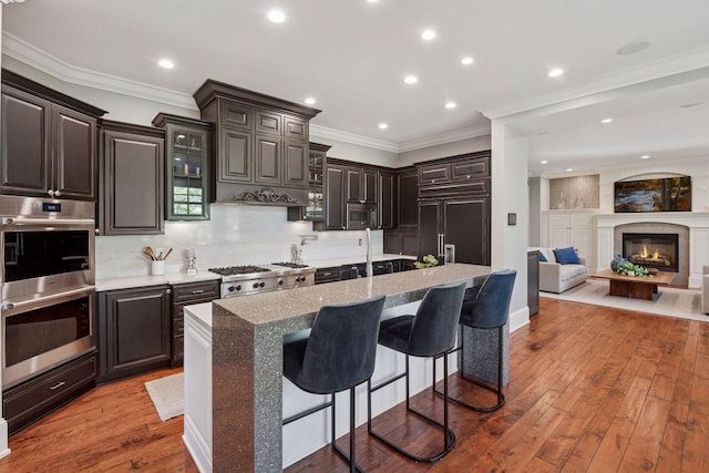 849 Brown Rd N, Orono, MN 55356 - kitchen with stainless steel appliances, a kitchen breakfast bar, hardwood / wood-style floors, tasteful backsplash, and recessed lighting