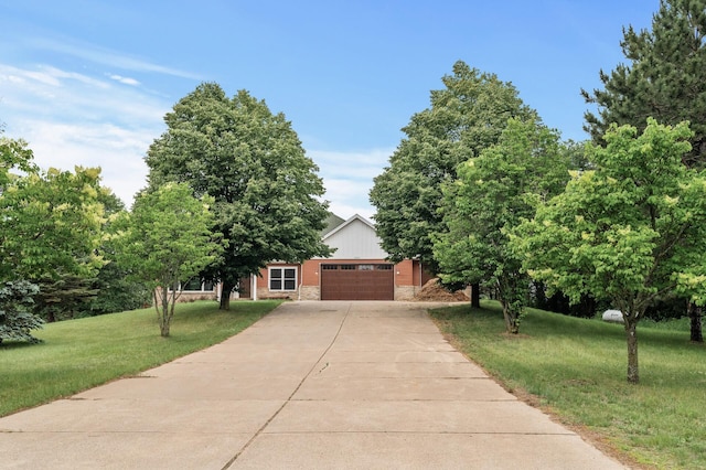 2801 263rd Ave NE, Isanti, MN 55040 - obstructed view of property featuring a garage, driveway, a front yard, and stone siding