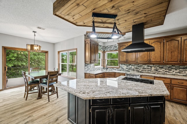 2801 263rd Ave NE, Isanti, MN 55040 - kitchen with island exhaust hood, light wood-style floors, a center island, tasteful backsplash, and a textured ceiling