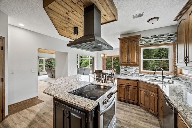 2801 263rd Ave NE, Isanti, MN 55040 - kitchen with island exhaust hood, stainless steel appliances, a textured ceiling, light wood-style floors, and light stone counters