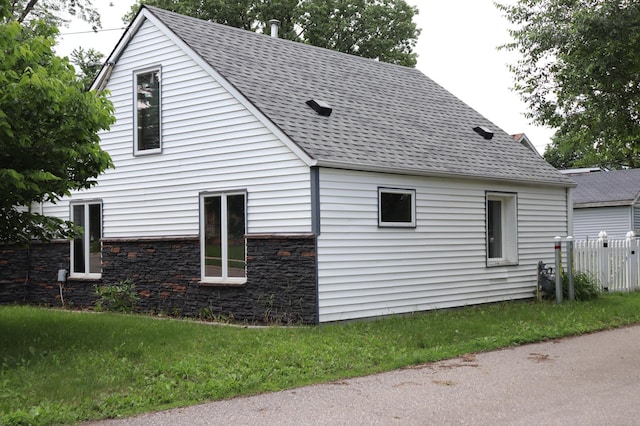 511 3rd St NE, Saint Cloud, MN 56304 - view of side of home featuring a shingled roof and stone siding