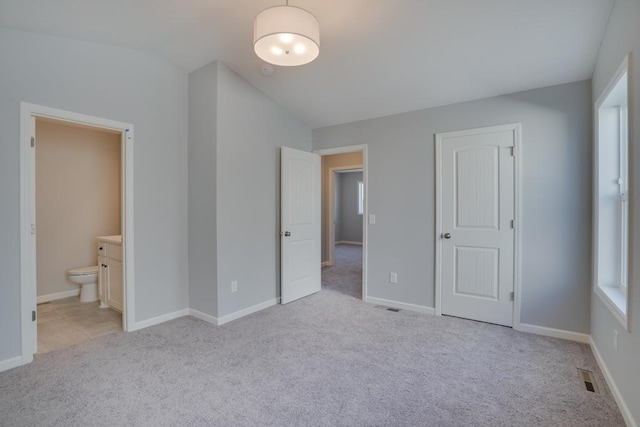 19916 English Ln N, Forest Lake, MN 55025 - unfurnished bedroom with light colored carpet, ensuite bathroom, vaulted ceiling, and multiple windows