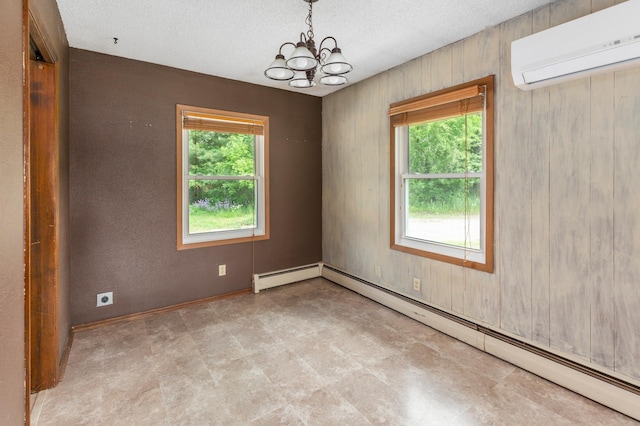 7 Pleasant Ave SE, Remer, MN 56672 - spare room with a baseboard heating unit, a wall mounted air conditioner, a chandelier, tile patterned floors, and a textured ceiling
