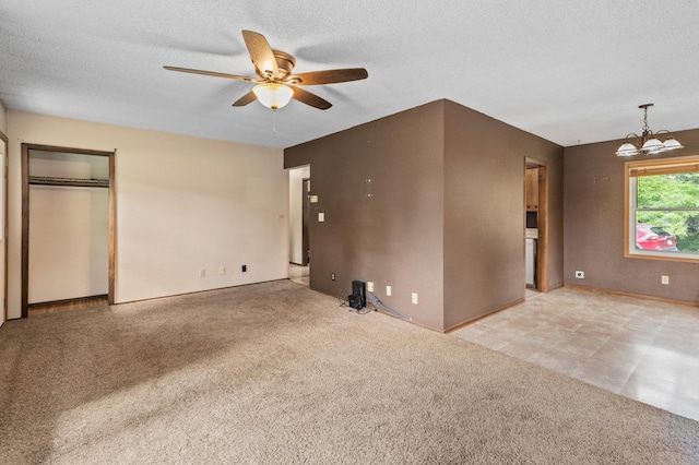 7 Pleasant Ave SE, Remer, MN 56672 - unfurnished living room with ceiling fan, a chandelier, carpet floors, and a textured ceiling