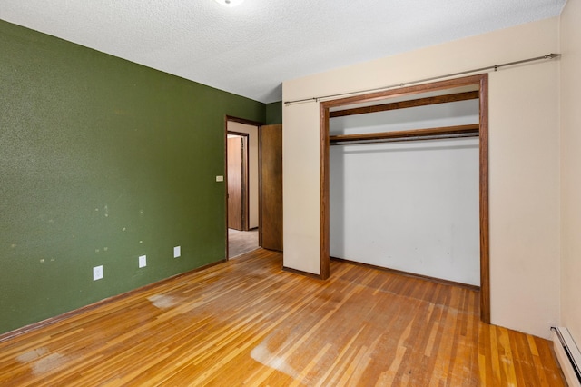 7 Pleasant Ave SE, Remer, MN 56672 - unfurnished bedroom with baseboard heating, wood finished floors, and a closet