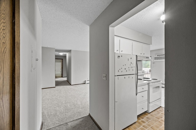 814 9th Ave S Unit 5, Hopkins, MN 55343 - kitchen with white appliances, a textured ceiling, white cabinets, under cabinet range hood, and light colored carpet