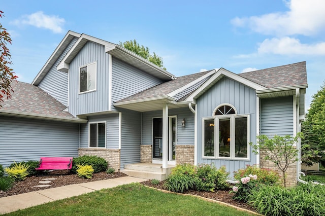 121 Arbor St, Northfield, MN 55057 - view of front of property with roof with shingles, board and batten siding, a front yard, and covered porch