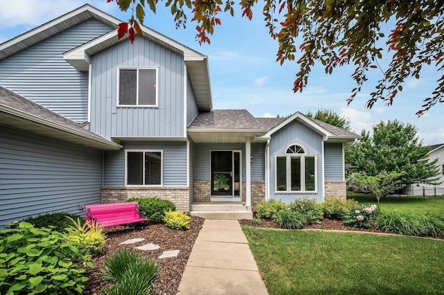 121 Arbor St, Northfield, MN 55057 - view of front of home with brick siding, a front lawn, board and batten siding, and roof with shingles