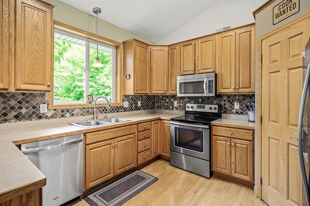 121 Arbor St, Northfield, MN 55057 - kitchen featuring stainless steel appliances, lofted ceiling, light wood finished floors, tasteful backsplash, and decorative light fixtures