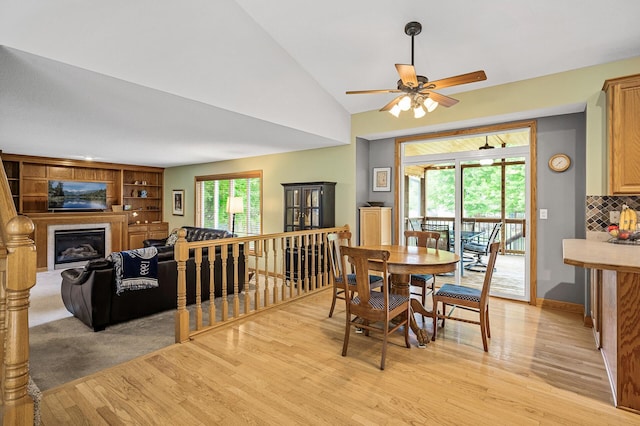 121 Arbor St, Northfield, MN 55057 - dining area with light wood-type flooring, a glass covered fireplace, ceiling fan, and lofted ceiling