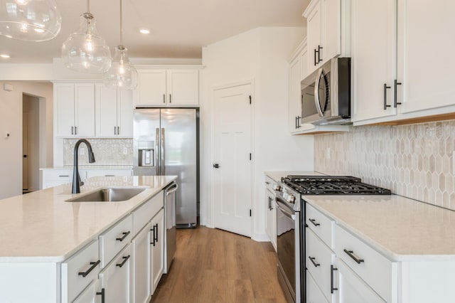 9734 49th St NE, Saint Michael, MN 55376 - kitchen with stainless steel appliances, wood finished floors, a kitchen island with sink, white cabinets, and recessed lighting
