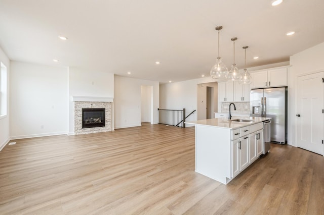 9734 49th St NE, Saint Michael, MN 55376 - kitchen featuring stainless steel appliances, a kitchen island with sink, white cabinetry, recessed lighting, and tasteful backsplash