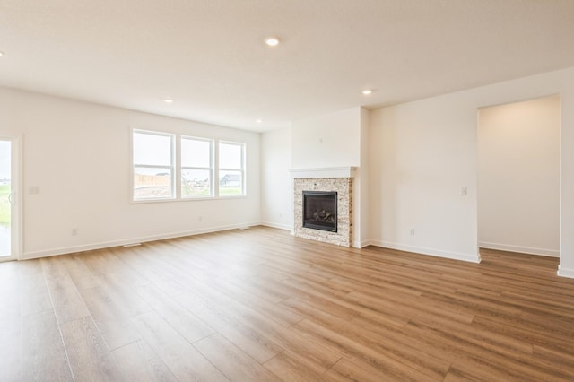 9734 49th St NE, Saint Michael, MN 55376 - unfurnished living room featuring light wood-type flooring, recessed lighting, and a glass covered fireplace