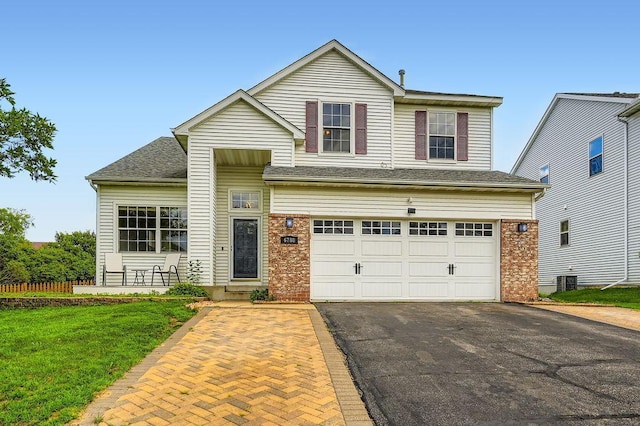 6788 Carlisle Curv, Shakopee, MN 55379 - traditional home with driveway, an attached garage, brick siding, a front yard, and roof with shingles