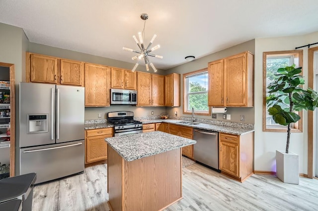 6788 Carlisle Curv, Shakopee, MN 55379 - kitchen featuring stainless steel appliances, a chandelier, light wood-type flooring, and light stone counters